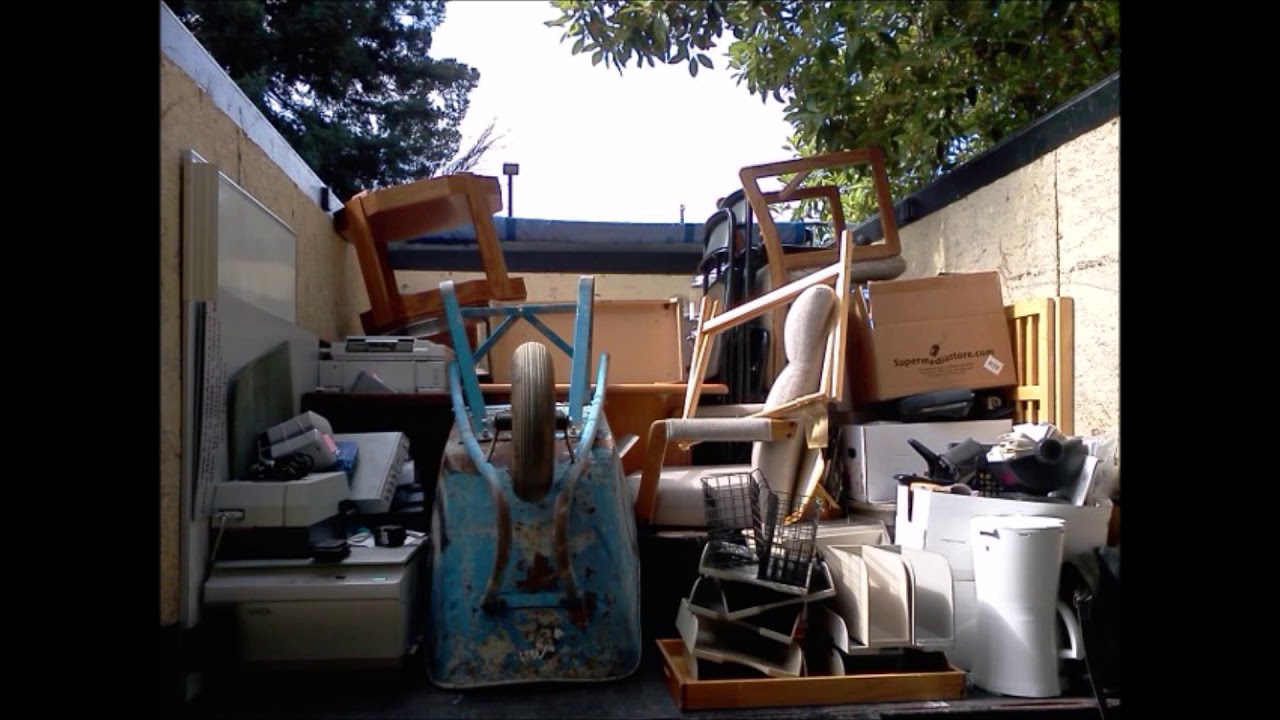 Furniture removal services Kent WA clearing out old chairs, office furniture, appliances, and debris loaded into a removal truck.